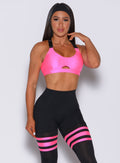 Front profile view of a model wearing our glow sports bra in neon pink and a matching leggings