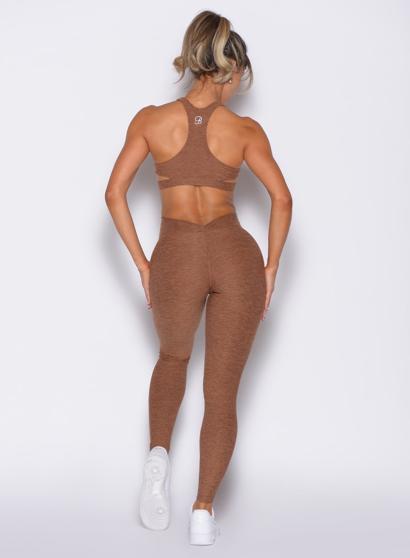 back profile view of a model with both hands on her thighs wearing the V Butt Lift Leggings in Coffee Bean color