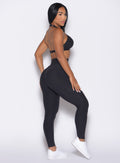 right side profile view of a model wearing the Movement Leggings in Heathered Black color