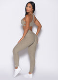 left side profile view of a model looking over her shoulder wearing the V Butt Lift Leggings in Toasted Sugar color