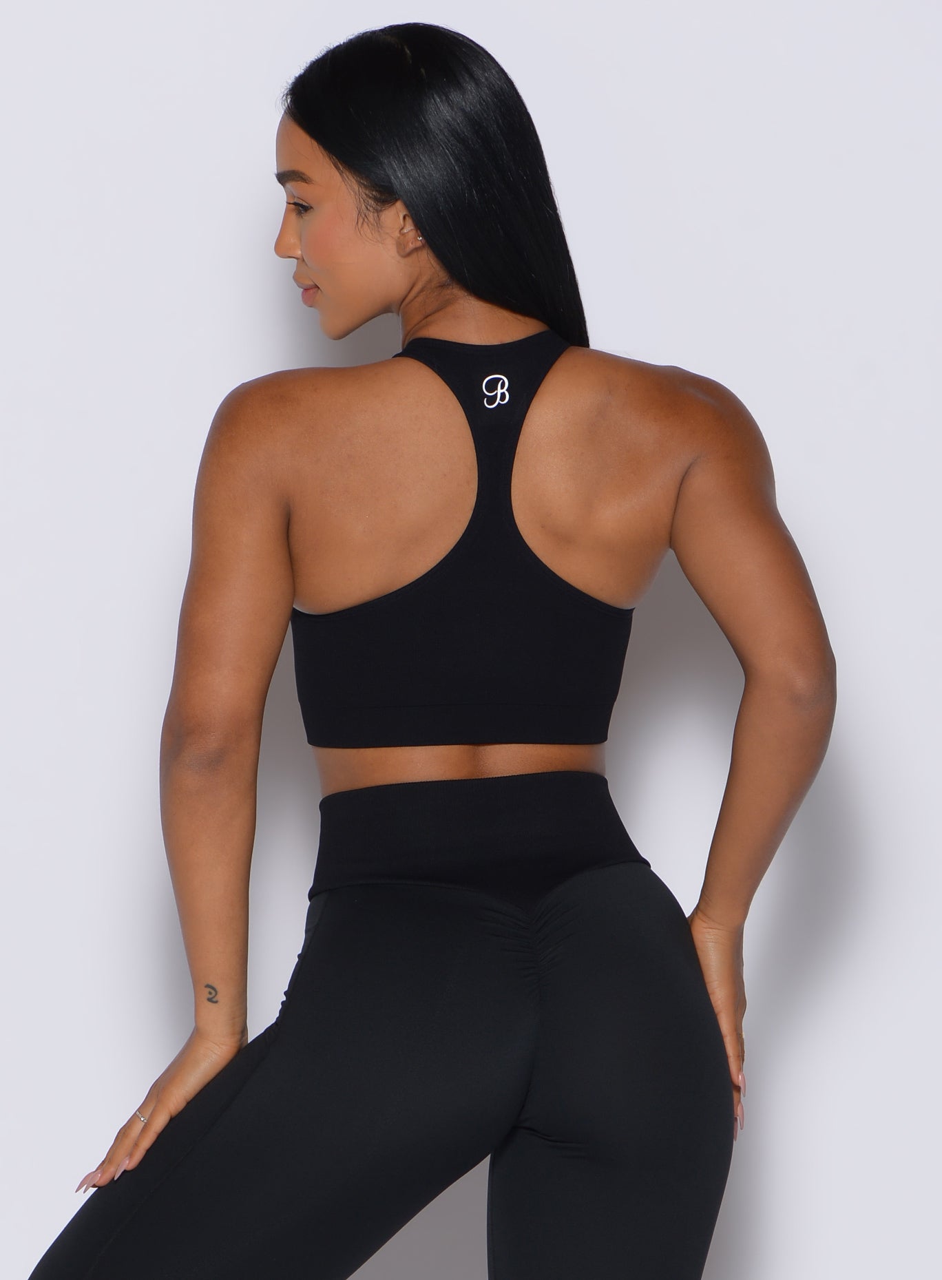 Back profile view of our model facing to the left wearing the Lifter Seamless Bra in Black color