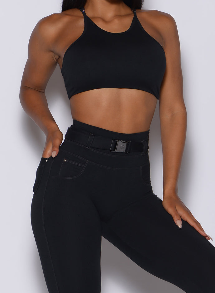 close up front profile view of a model in our black high neck crop bra and a matching leggings