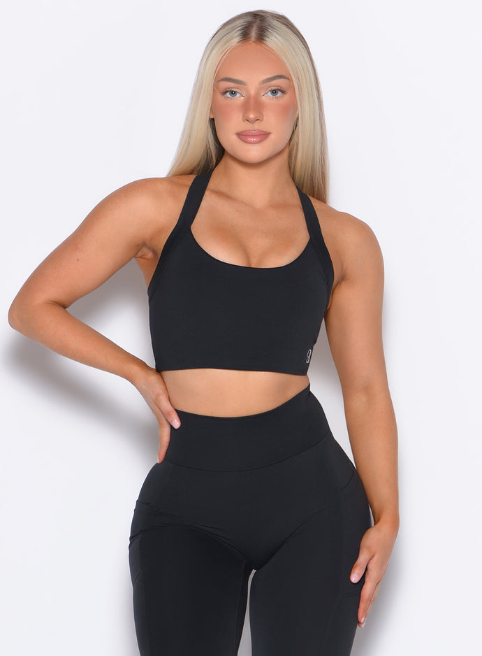 front profile view of a model wearing our High Impact Bra in Black color and the matching leggings
