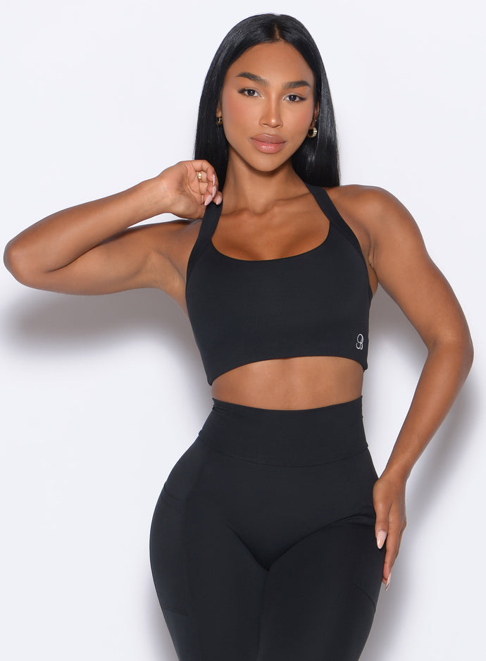 Model facing forward wearing our High Impact Bra in Black color and the matching leggings
