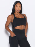 front profile view of a model posing in our High Impact Bra in Black color and the matching leggings
