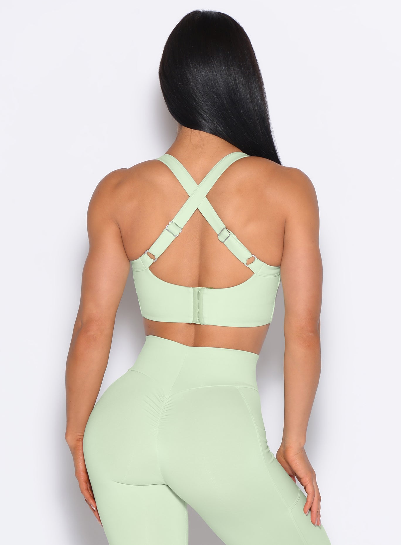 Back side close up view of model wearing the High Impact Bra in Cool Matcha color and the matching leggings
