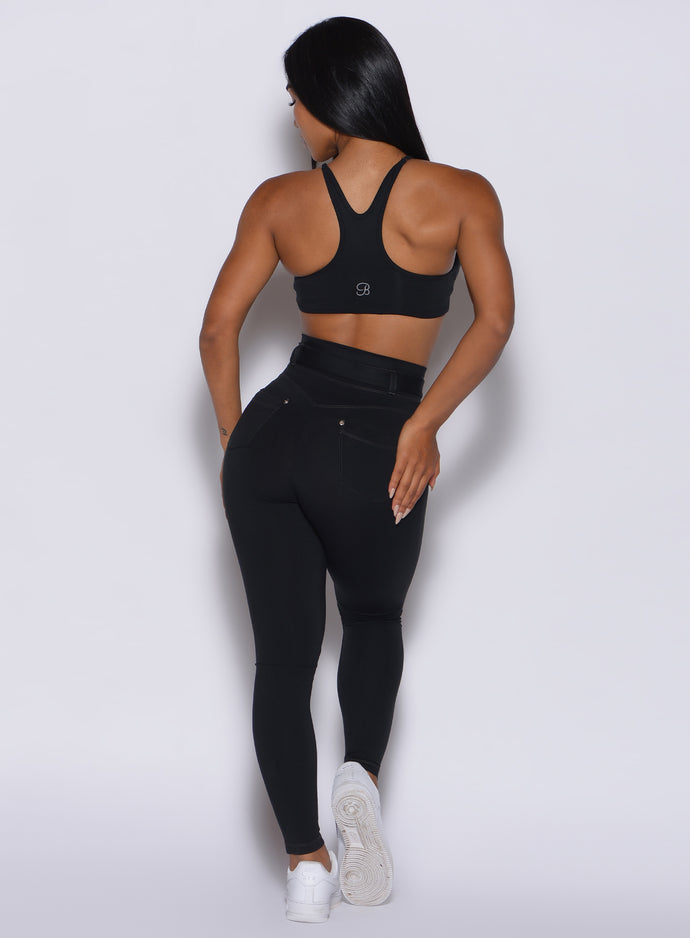 back profile view of a model wearing our black peach bottoms leggings along with the matching sports bra