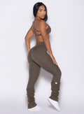 right side profile view of a model looking over her shoulder wearing the Internal Scrunch Leggings in winter oak color