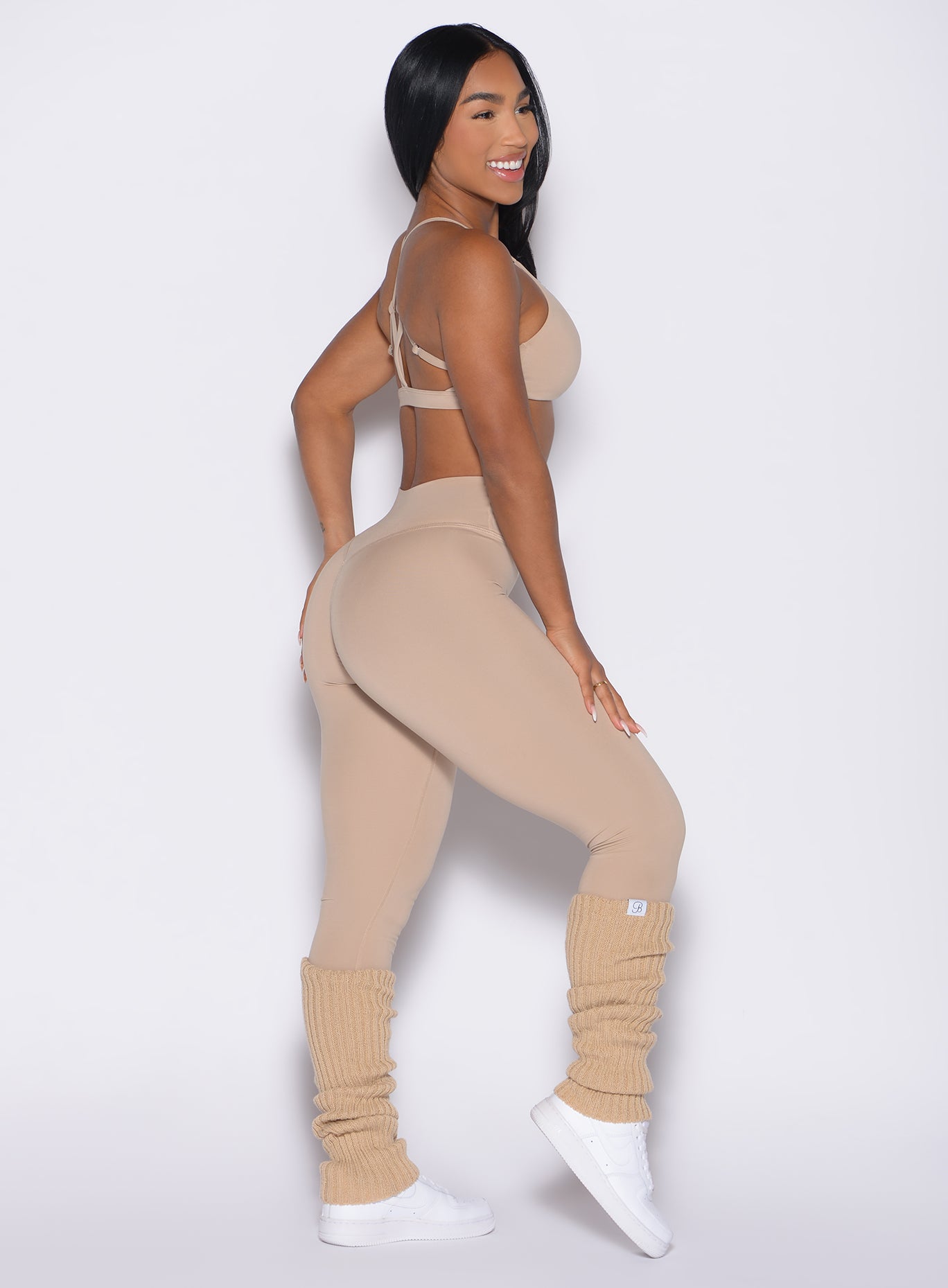 right side profile view of a model wearing the Internal Scrunch Leggings in Glacial beige color