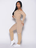 left side profile view of a model wearing the Internal Scrunch Leggings in Glacial beige color paired with the matching pullover