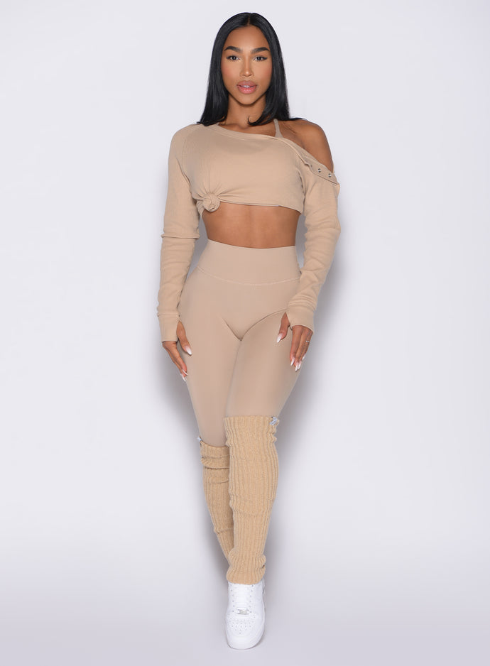 front profile view of a model wearing the Internal Scrunch Leggings in Glacial beige color paired with the matching pullover and leg warmers