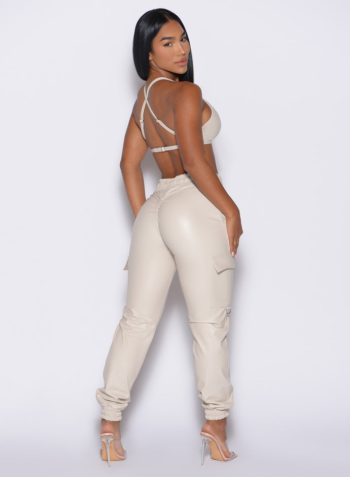 back right side profile view of our model looking over her shoulder wearing the Liquid Cargos in champagne color