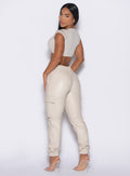 back left side profile view of our model looking over her shoulder wearing the Liquid Cargos in champagne color