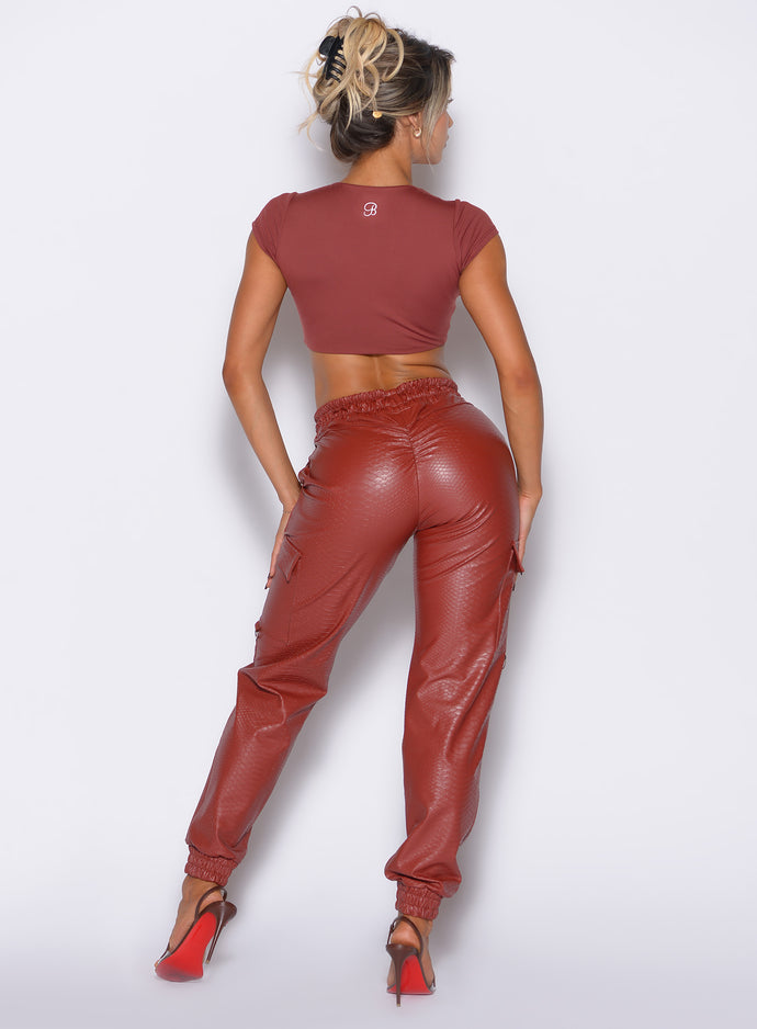 back profile view of our model facing to the right side wearing the Liquid Cargos in brick red color