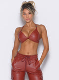 front profile view of our model with both hands inside the pockets of the matching liquid cargos wearing the Liquid Kini Bra in brick red color