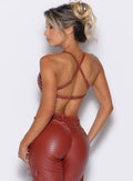 back profile view of our model facing to the left side wearing the Liquid Kini Bra in brick red color