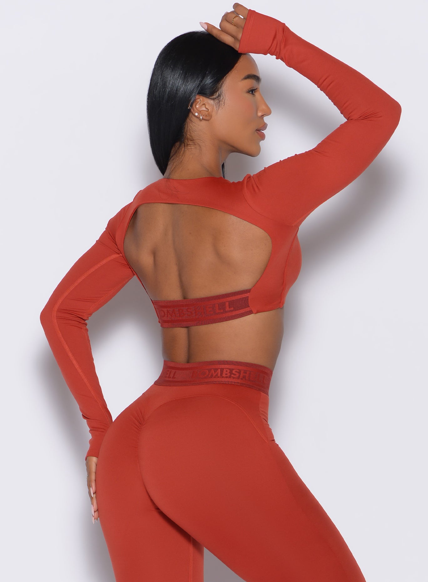 back right side profile view of our model wearing the Bombshell Active Pullover in red ochre color