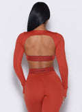 back profile view of our model wearing the Bombshell Active Pullover in red ochre color