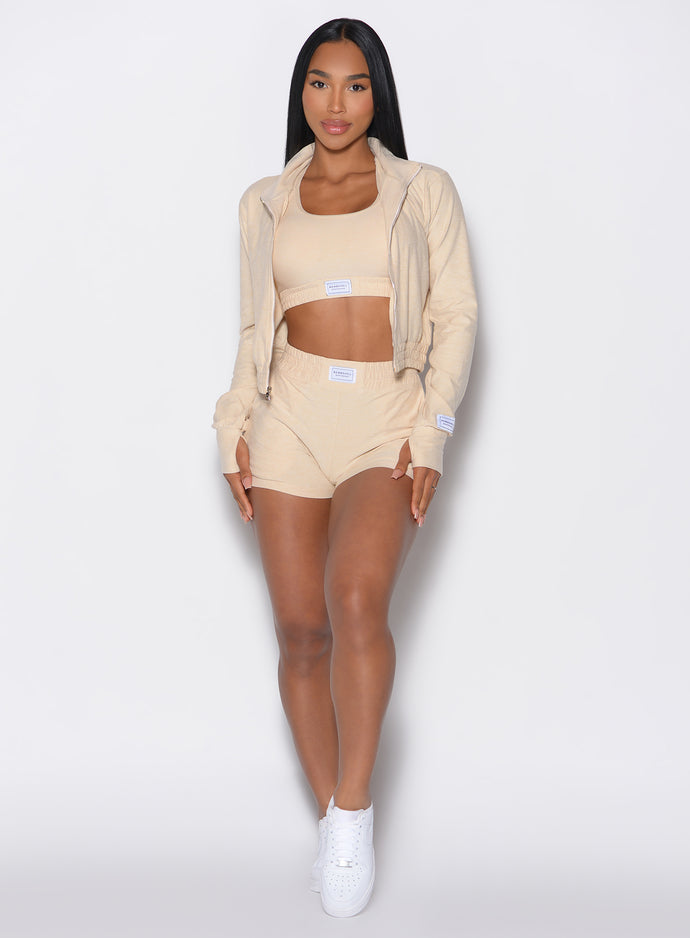 Front profile view of our model wearing the Cloud Comfort Shorts in vanilla color paired with the matching bra and jacket 