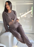 model in indoors leaning on a couch wearing the Gym Crush Hoodie in Cozy chocolate color