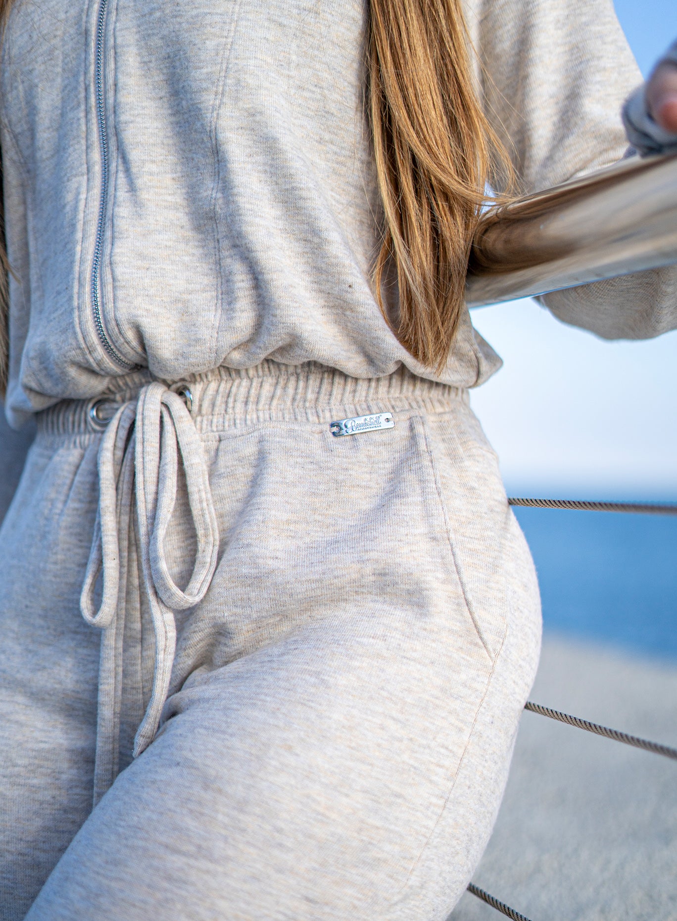 close up view of a model wearing the Flirty Jumpsuit in Cozy oat color