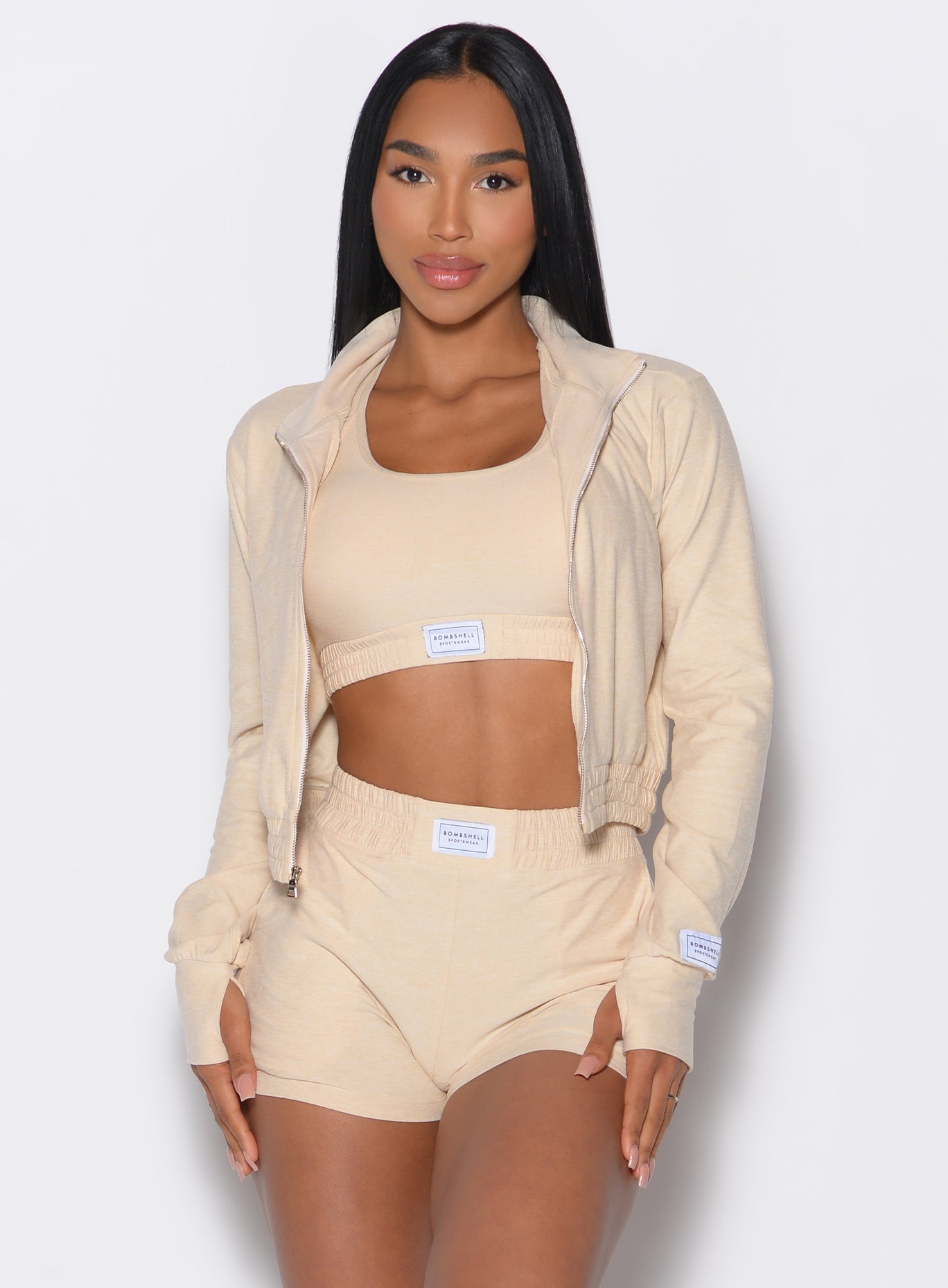 Front profile view of our model wearing the Cloud Full Length Jacket in vanilla color paired with the matching shorts and bra