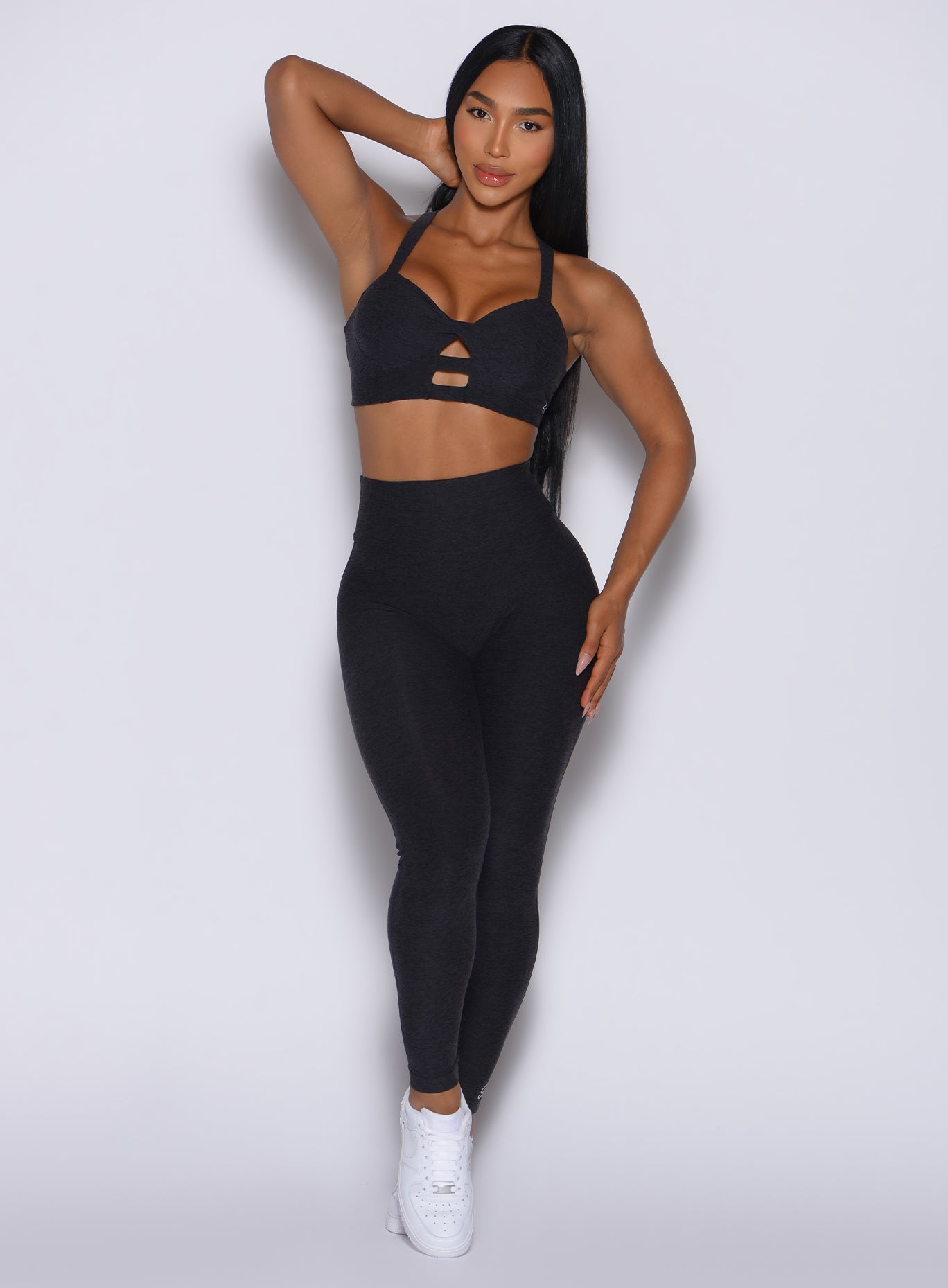Model facing forward wearing our Movement Leggings in black Onyx color and a matching sports bra