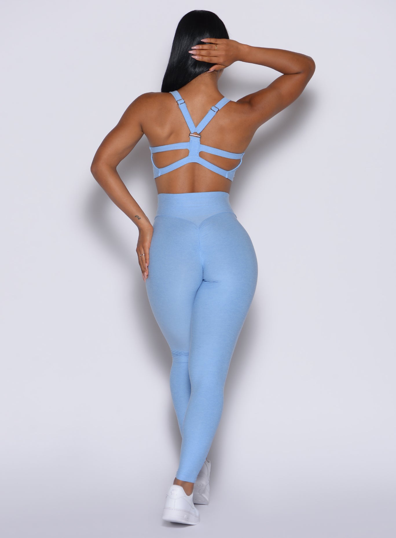 back profile picture of a model in our Movement Leggings in Bright Hydrangea color and a matching Sports Bra