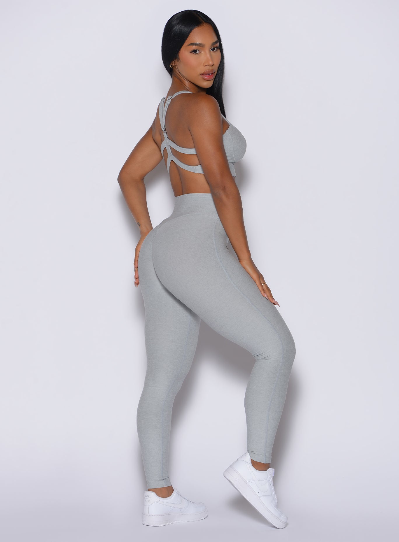 Right side view of a model facing to her right wearing our Movement Leggings in Light Cloud color and a matching Sports Bra