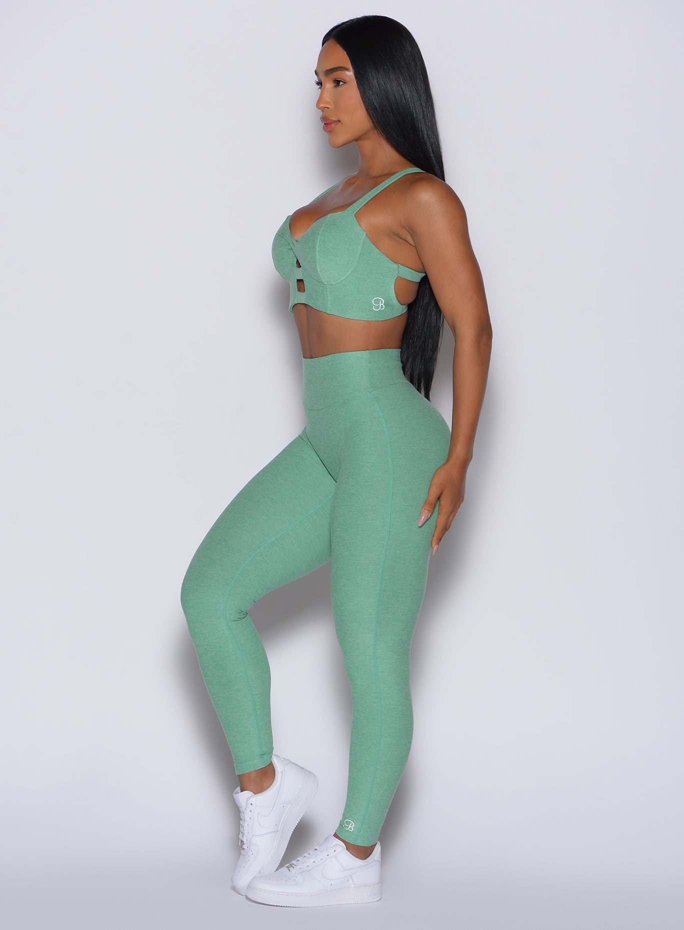 Left side view of model wearing our Movement Leggings in Sage color and a matching Sports Bra