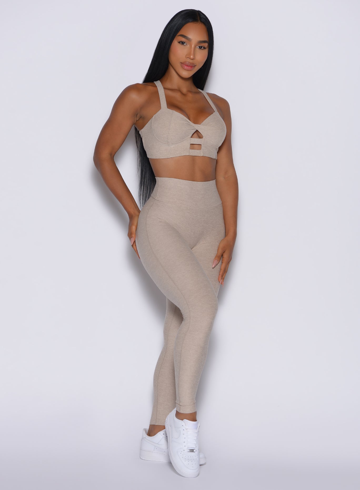 front profile picture of a model in our Movement Leggings in Taupe color and a matching Sports Bra 