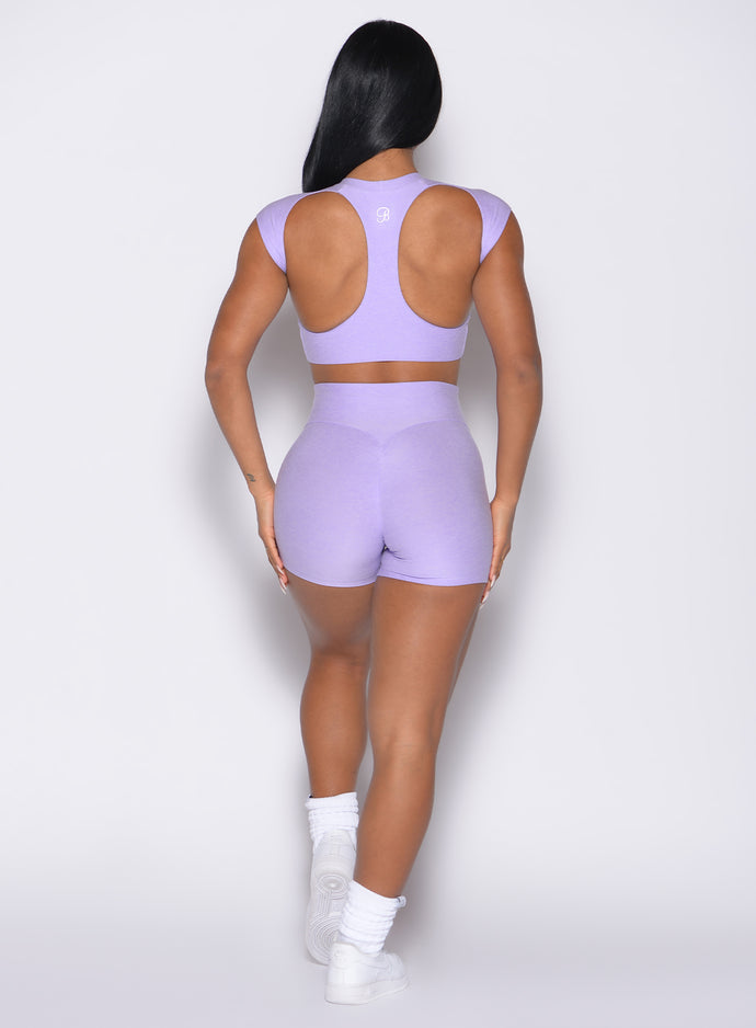 back profile view of a model wearing the Movement Shorts in Sugared Lilac color paired with the matching tee