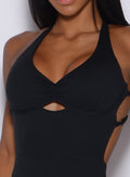 Picture of a model showing her cleavage and wearing a black bodysuit 