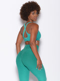 Right side profile view of a model in our toggle sports bra in Ombre Ibiza Green and a matching leggings  