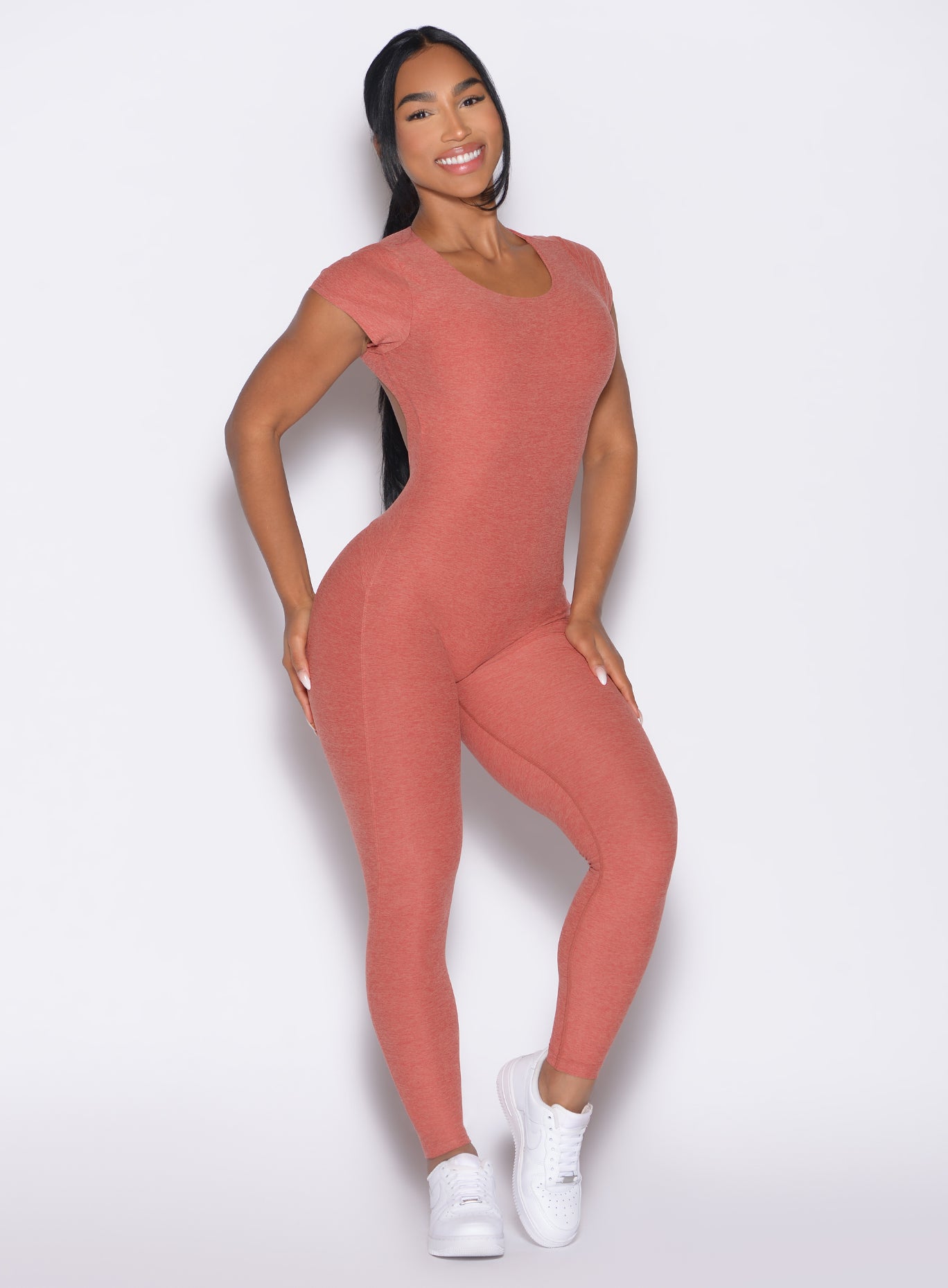 front right side profile view of a model wearing the Open Back Tee Bodysuit in Georgia Peach color