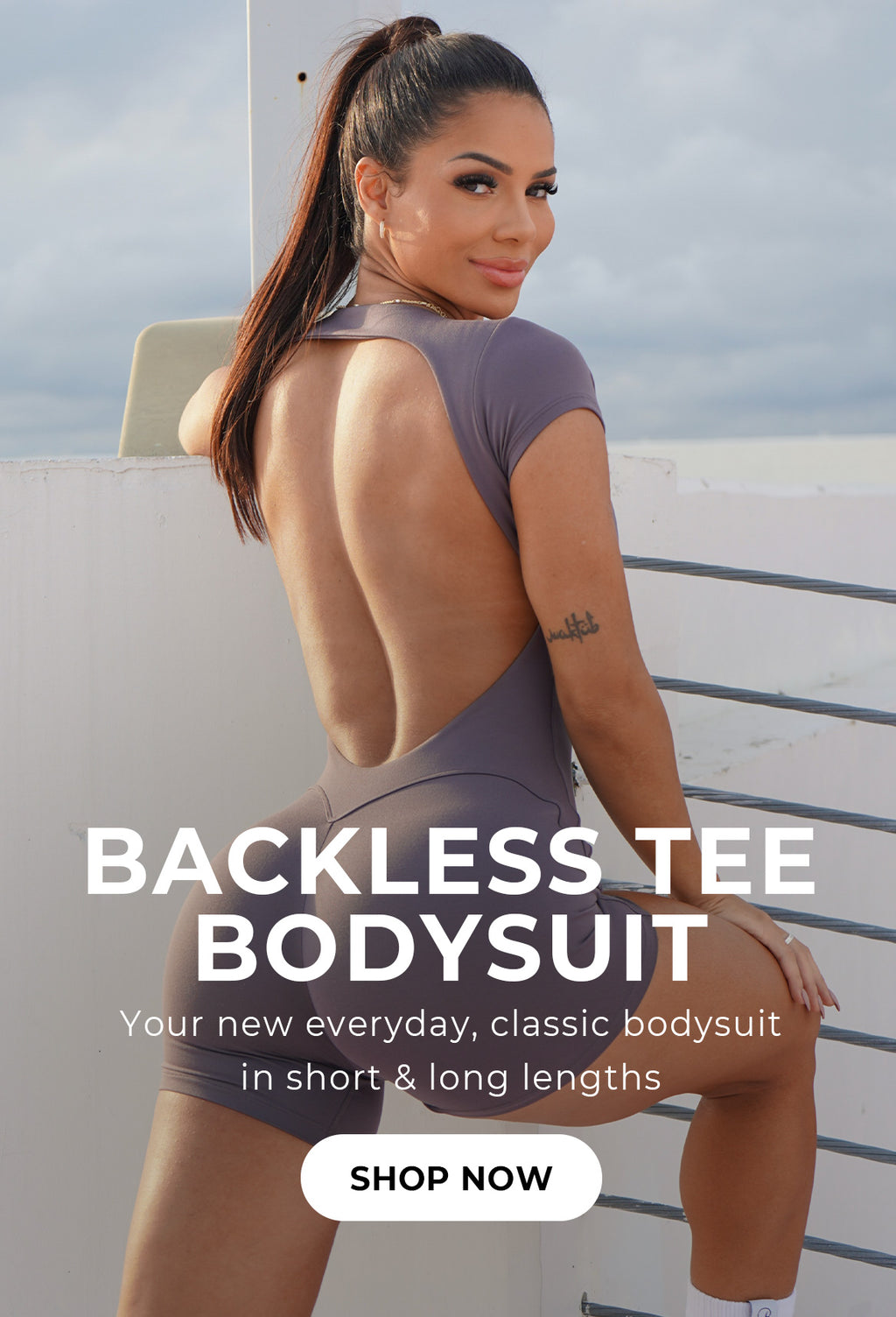 Image is a back profile image of model stretching in the gray smoke open back bodysuit shorts with text overlay that reads "BACKLESS TEE BODYSUIT Your new everyday, classic bodysuit in short and long lengths" call to action button says SHOP NOW