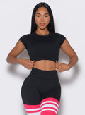 front  profile view of a model wearing our black open back tee along with a matching thigh high leggings