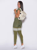 left side profile view of our model with Bombshell X Wolfpak backpack wearing the Perform Thigh Highs in Lily pad color