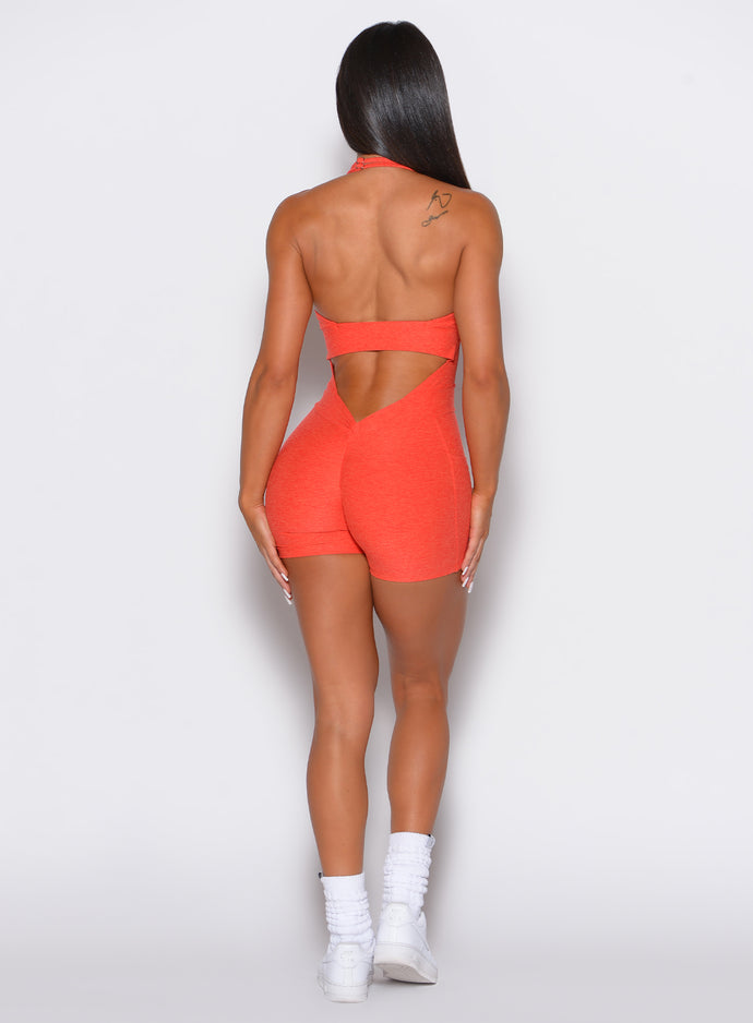 back profile view of a model wearing our Backless Pocket Bodysuit Short in apricot color