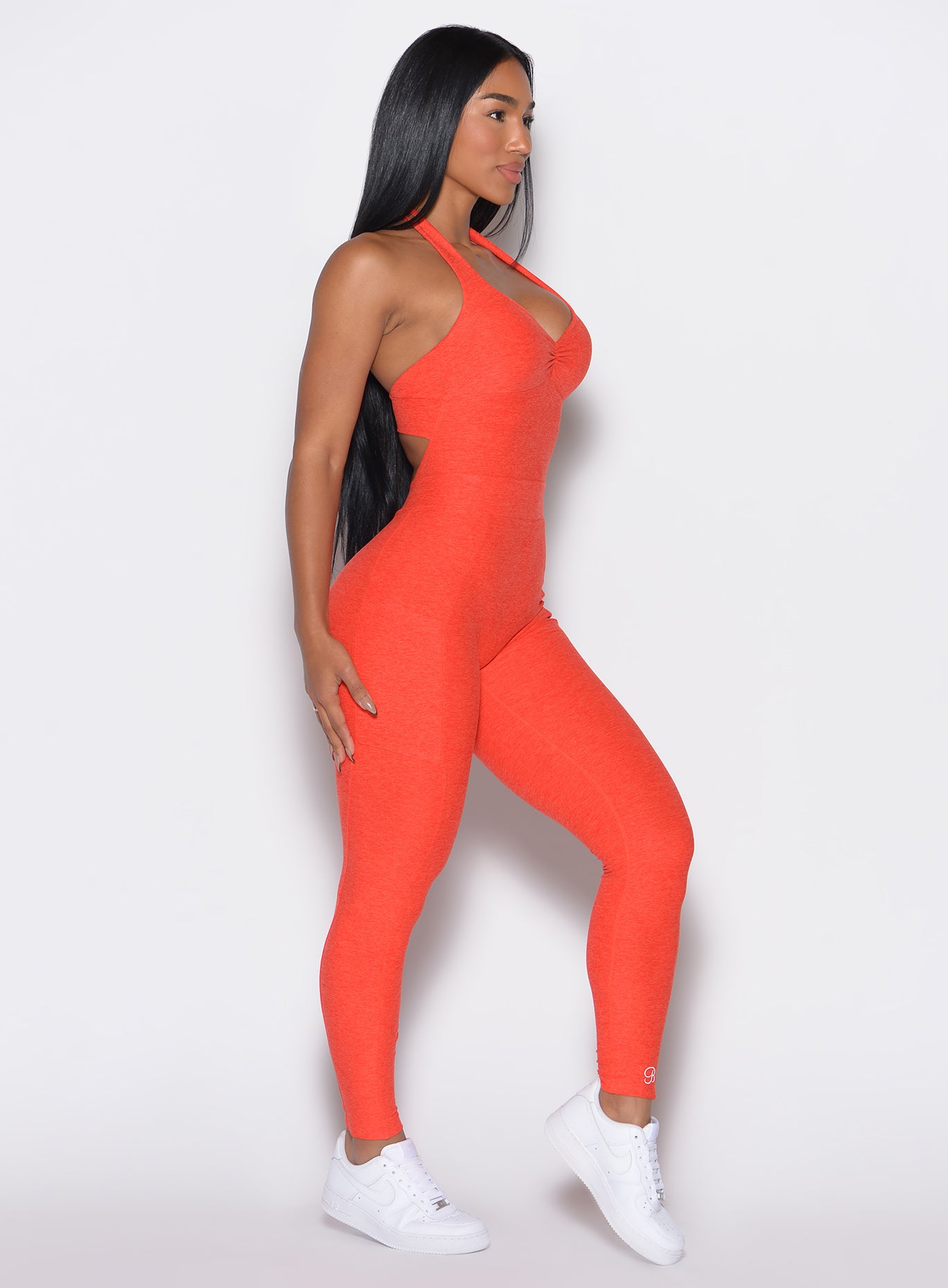 right side profile view of a model wearing our Backless Pocket Bodysuit in apricot color