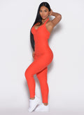 left side profile view of a model facing the camera wearing our Backless Pocket Bodysuit in apricot color