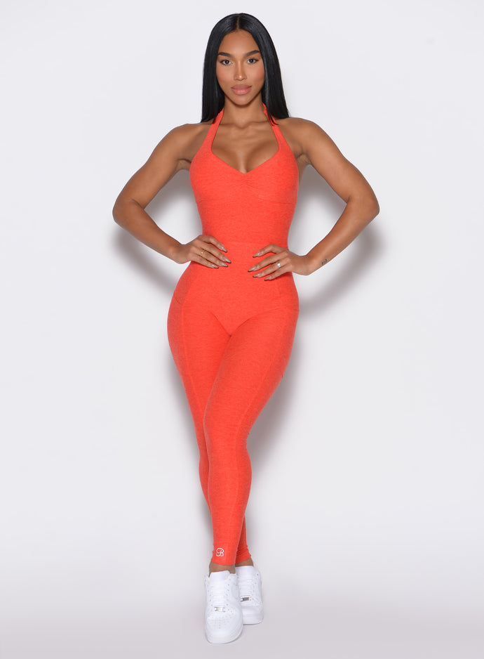 front profile view of a model with her hands on waist wearing our Backless Pocket Bodysuit in apricot color