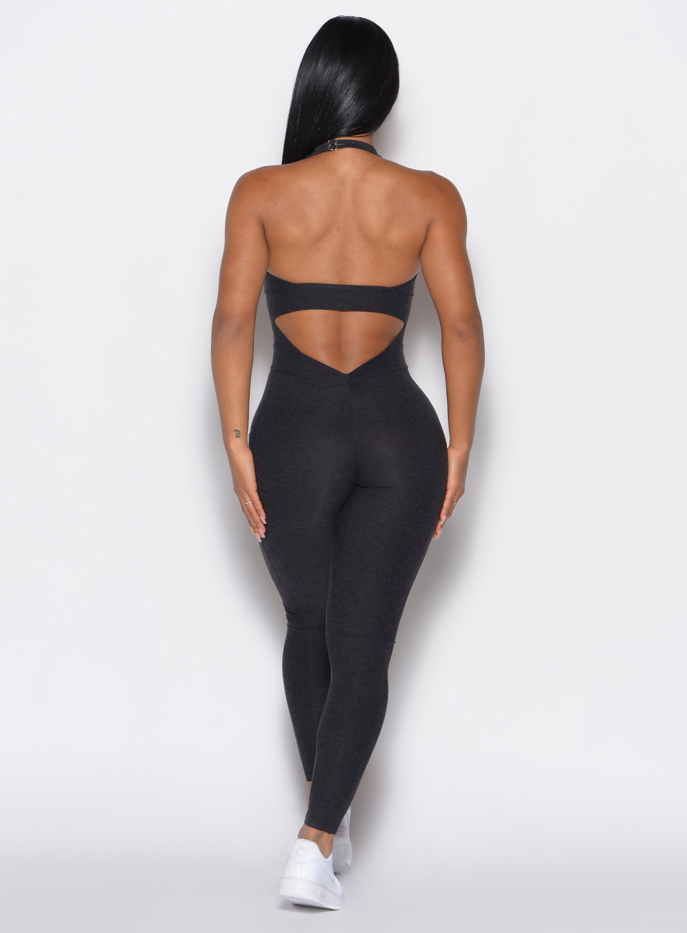 back profile view of a model wearing our Backless Pocket Bodysuit in onyx black