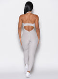 back profile view of a model wearing our Backless Pocket Bodysuit in ice color