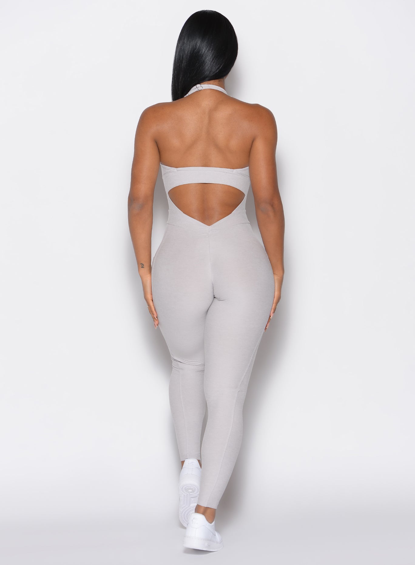 back profile view of a model wearing our Backless Pocket Bodysuit in ice color