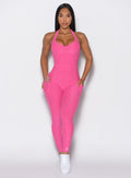 front profile view of a model wearing our Backless Pocket Bodysuit in pink glo color