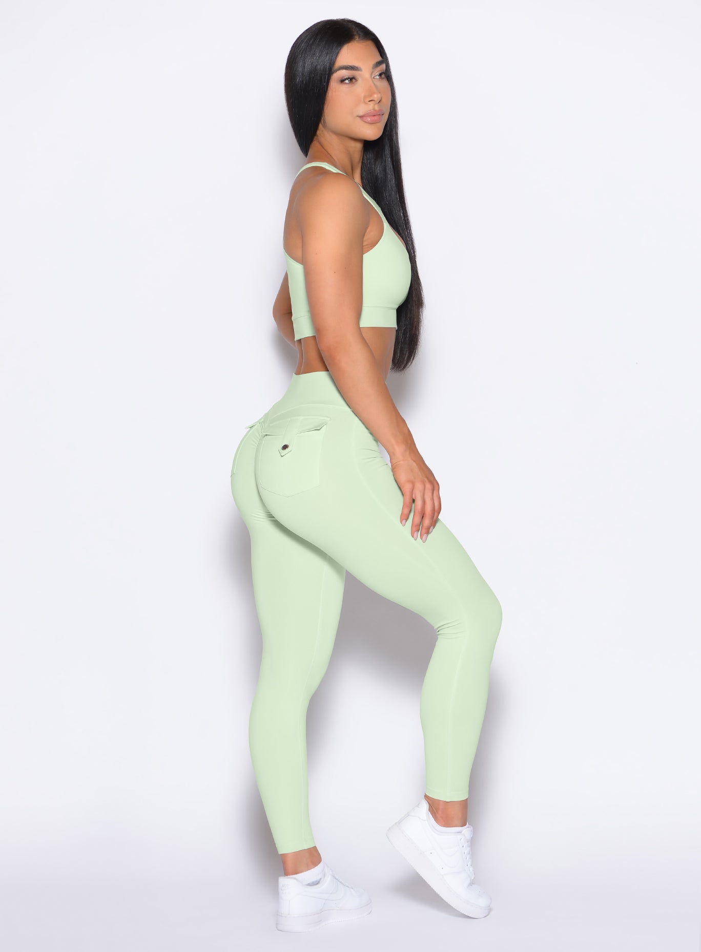 right side profile view of a model wearing our Pocket Pop Leggings 2.0 in Cool Matcha color and the matching bra
