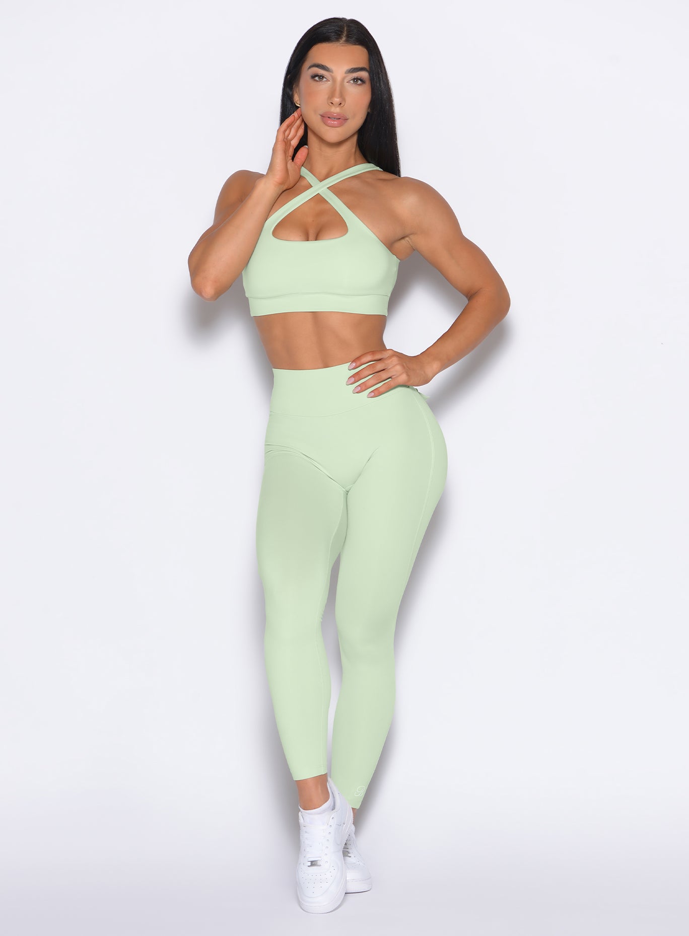 Model facing forward wearing our Pocket Pop Leggings 2.0 in Cool Matcha color and the matching bra
