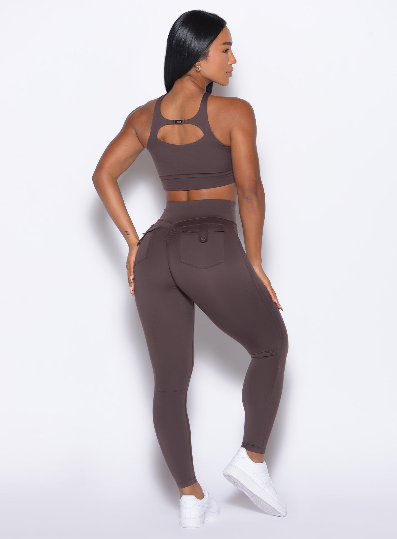 back profile of a model wearing the Pocket Pop Leggings 2.0 in Seal Brown color and the matching bra
