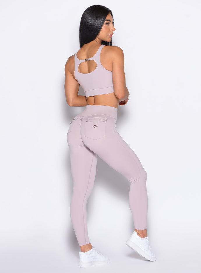 back profile of a model looking to her right wearing the Pocket Pop Leggings 2.0 in Violet Ice color and the matching bra
